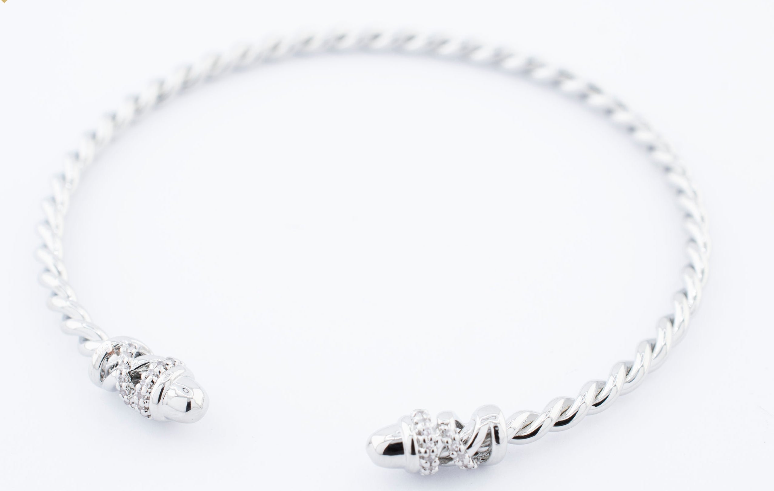 BRAZALETE TORCIDO PUNTA CRUZADA ZIRCONIAS CHAPA DE RODIO